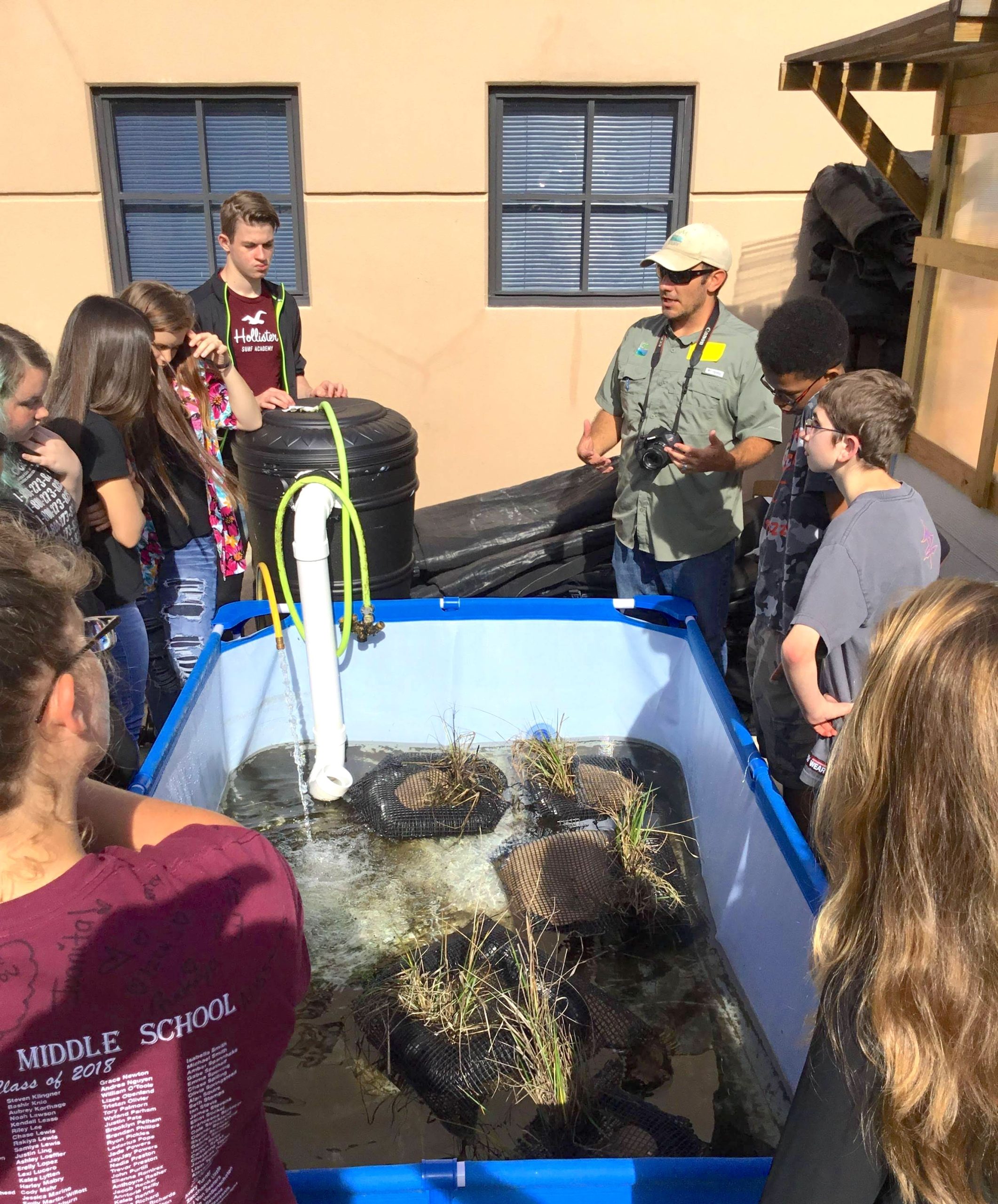 Image of Kenneth talking with middle school students about their hydroponic smooth cordgrass system.