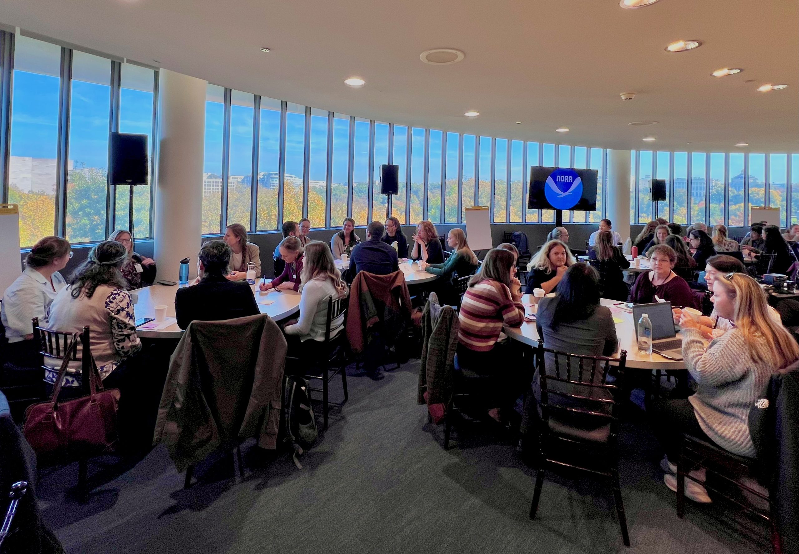 Image of a workshop with people sitting around a table
